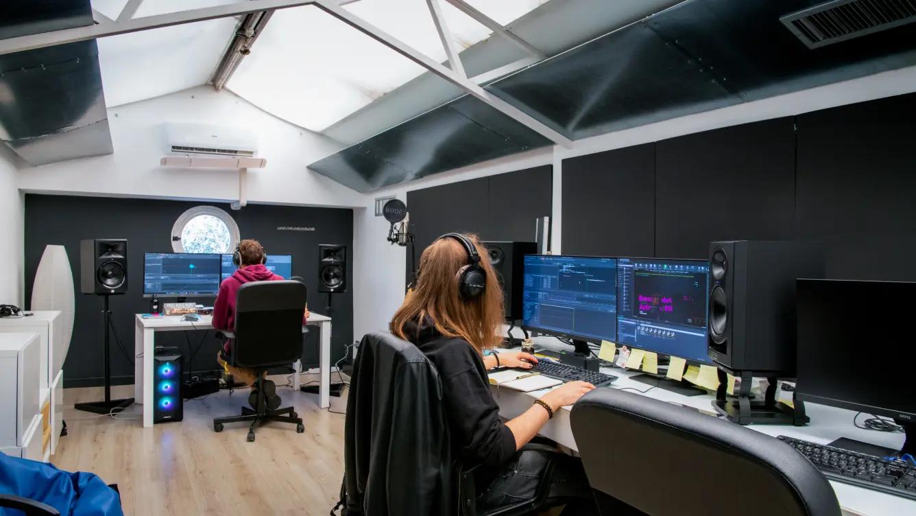 Modern office with a glass ceiling and people working on computers