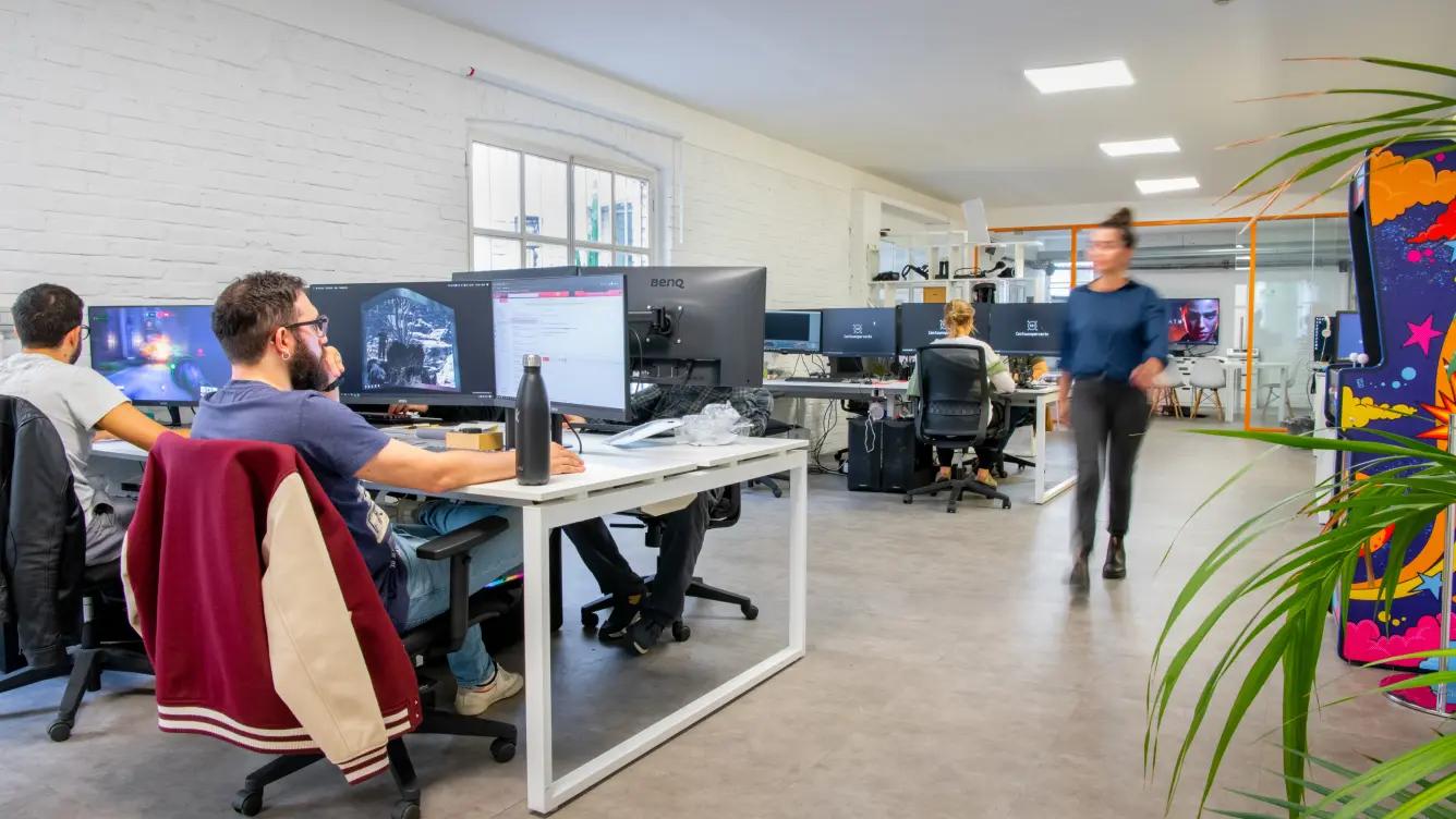 Workplace with people working on computers and a walking girl